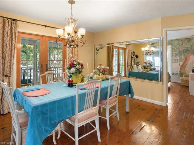 Dining space featuring an inviting chandelier, wood-type flooring, and french doors