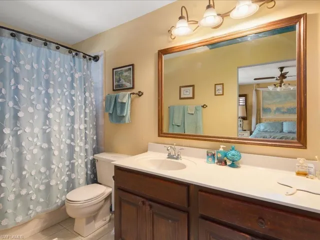 Bathroom featuring tile patterned flooring, vanity, ceiling fan, and toilet