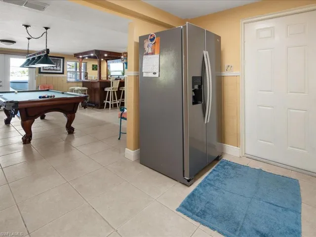 Rec room featuring light tile patterned floors, billiards, and indoor bar