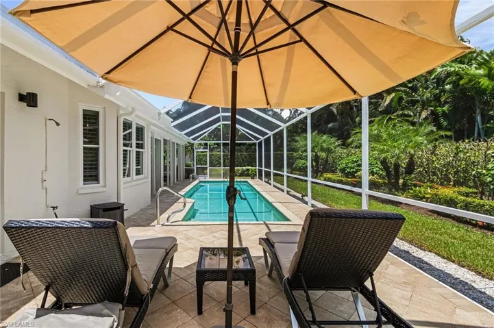 Swimming pool featuring a patio, a sunroom, and glass enclosure