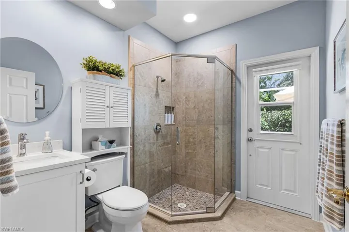 Bathroom featuring vanity, a shower stall, and light tile patterned floors