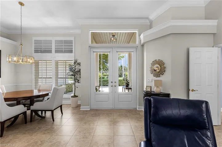 Entryway with french doors, crown molding, and light tile patterned floors