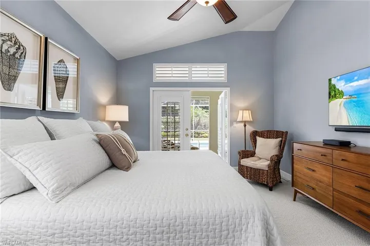 Carpeted bedroom featuring access to outside, lofted ceiling, ceiling fan, and french doors