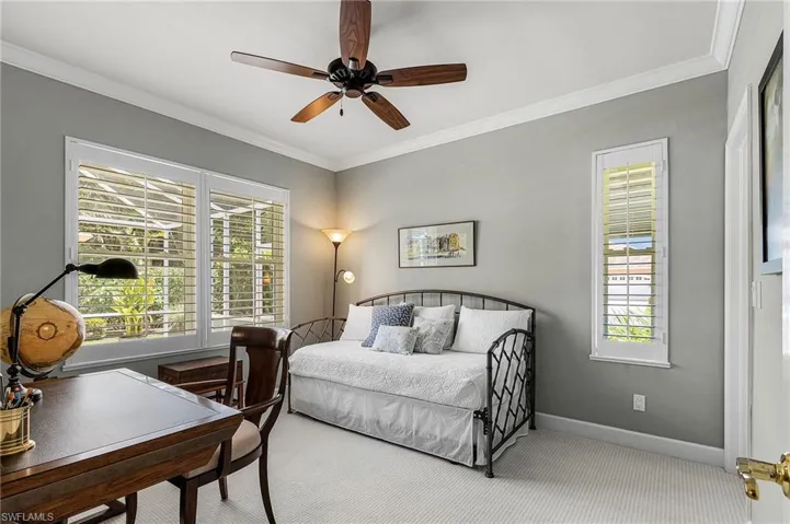 Bedroom with crown molding, carpet flooring, and a ceiling fan