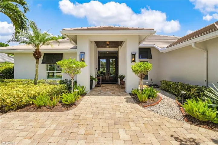 Entrance to property with french doors, stucco siding, and a tile roof
