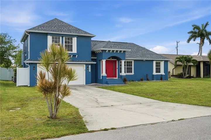 Contemporary blue exterior with a prominent red entry door, white trim accents, and a two-car garage
