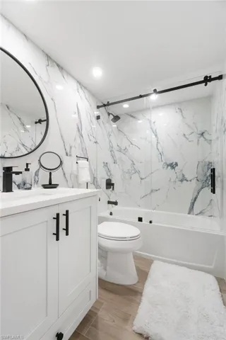 Full primary bathroom en-suite with custom quartz, full wall statement porcelain stone tile shower and walls, custom mirror andhardware