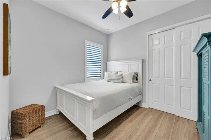Bedroom featuring light wood-type flooring, a ceiling fan, and a closet