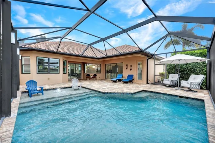 Swimming pool featuring a patio, a sunroom, and glass enclosure