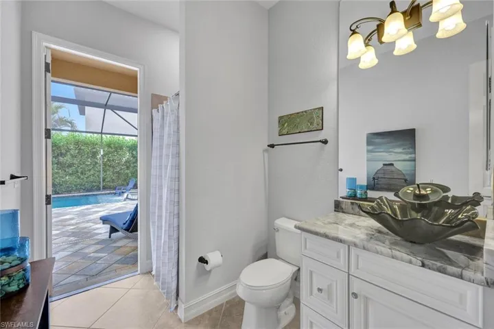 Full bathroom featuring vanity, curtained shower, light tile patterned floors, and a chandelier