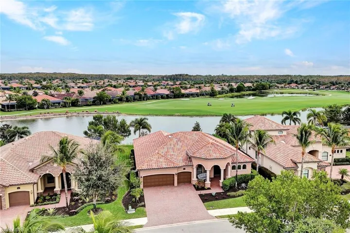 Aerial perspective of suburban area featuring a large body of water and a golf club