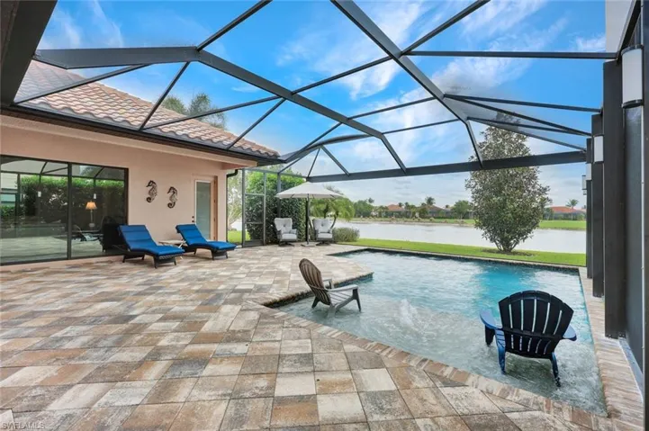 Outdoor pool with a sunroom, a patio area, a lanai, and a water view
