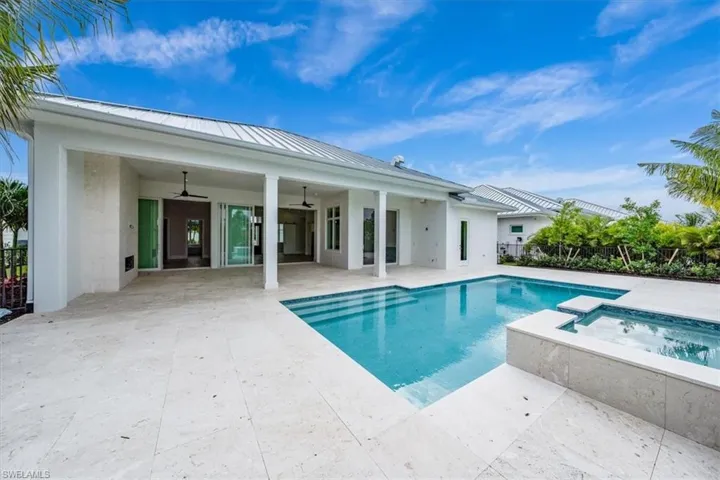 The outdoor living space features both covered and uncovered lounge spaces, a heated saltwater pool and spa, and natural gas fireplace. Soon to be added: An outdoor kitchen and motorized roll-down bug and storm screens (included in the purchase price).