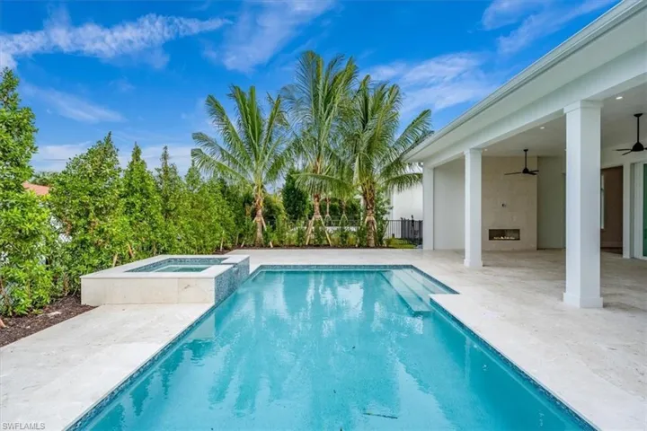 The outdoor living space features both covered and uncovered lounge spaces, a heated saltwater pool and spa, and natural gas fireplace. Soon to be added: An outdoor kitchen and motorized roll-down bug and storm screens (included in the purchase price).