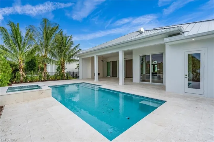 The outdoor living space features both covered and uncovered lounge spaces, a heated saltwater pool and spa, and natural gas fireplace. Soon to be added: An outdoor kitchen and motorized roll-down bug and storm screens (included in the purchase price).