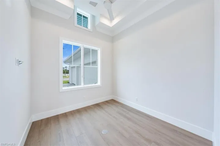 The office is located just off of the great room and features a large picture window, transom, and barn door entry.