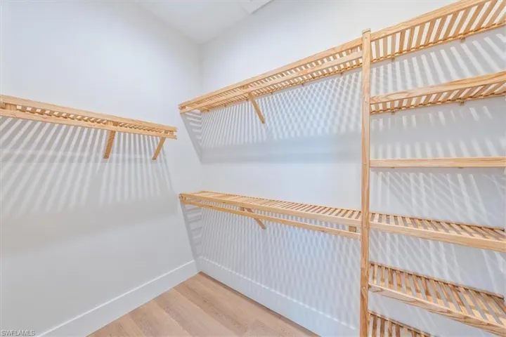 The primary suite features 10' sliders out to the pool deck, dual walk-in closets, and a spa bathroom with shower, free standing soaking tub, private WC, and two sinks.