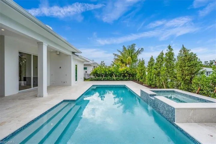 The outdoor living space features both covered and uncovered lounge spaces, a heated saltwater pool and spa, and natural gas fireplace. Soon to be added: An outdoor kitchen and motorized roll-down bug and storm screens (included in the purchase price).