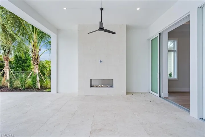 The outdoor living space features both covered and uncovered lounge spaces, a heated saltwater pool and spa, and natural gas fireplace. Soon to be added: An outdoor kitchen and motorized roll-down bug and storm screens (included in the purchase price).