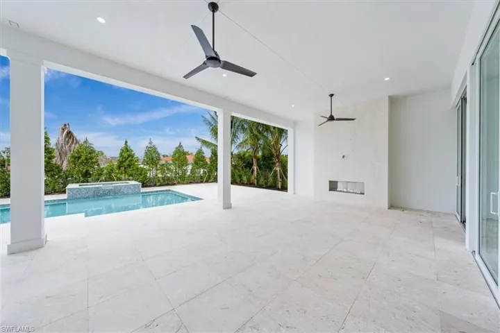 The outdoor living space features both covered and uncovered lounge spaces, a heated saltwater pool and spa, and natural gas fireplace. Soon to be added: An outdoor kitchen and motorized roll-down bug and storm screens (included in the purchase price).