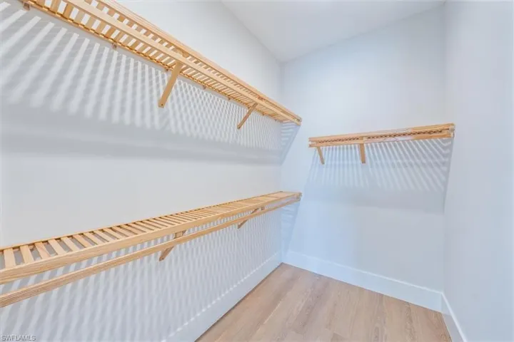 The primary suite features 10' sliders out to the pool deck, dual walk-in closets, and a spa bathroom with shower, free standing soaking tub, private WC, and two sinks.