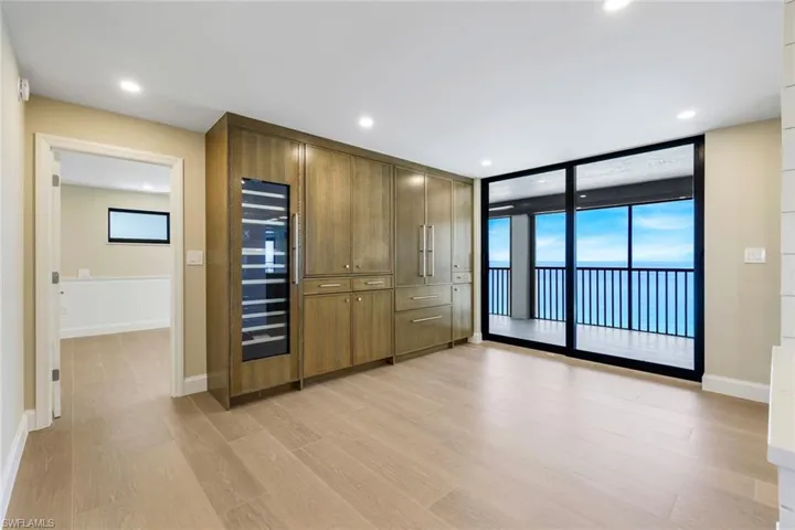 Breakfast area featuring access to exterior, light wood-style floors, wine cooler, floor to ceiling windows, and recessed lighting