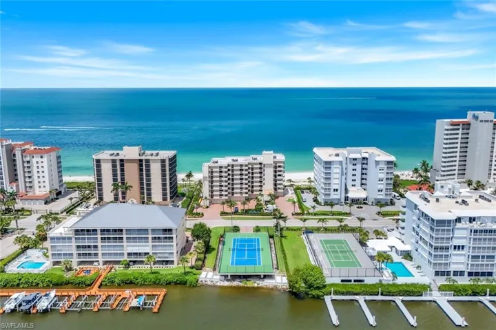 Drone / aerial view of a nearby body of water and a pool