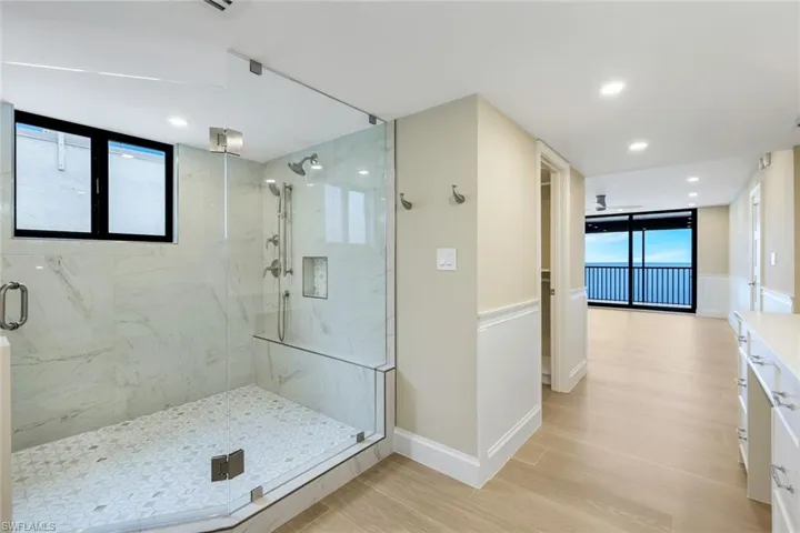 Bathroom with plenty of natural light, a marble finish shower, wood finished floors, and recessed lighting