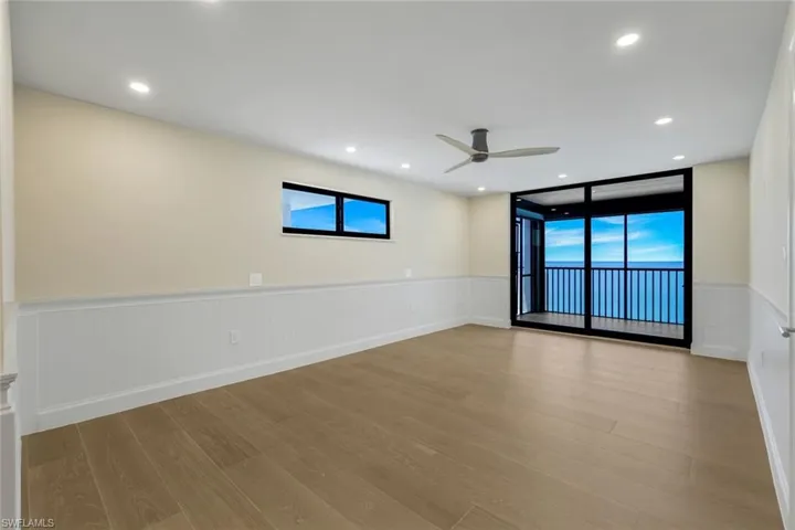Spare room featuring a wainscoted wall, ceiling fan, wood finished floors, recessed lighting, and a decorative wall