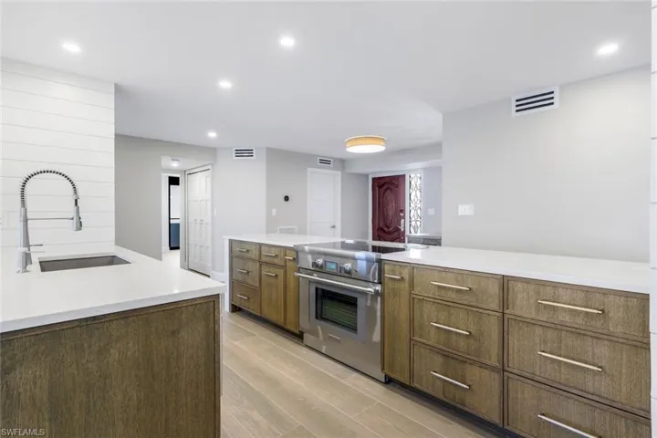 Kitchen with recessed lighting, stainless steel range, light wood-type flooring, and light countertops