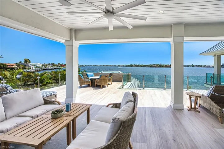 Wooden deck featuring an outdoor living space, ceiling fan, a water view, and outdoor dining area