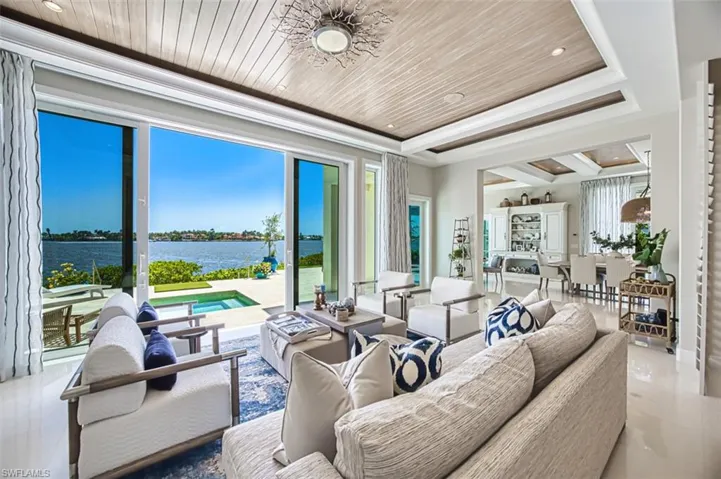 Living area with a water view, wooden ceiling, a raised ceiling, and recessed lighting