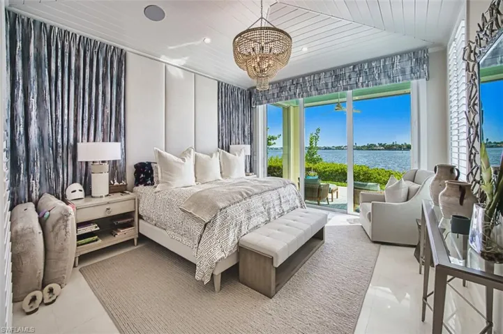 Bedroom featuring tile patterned floors, a chandelier, access to outside, a water view, and wood ceiling