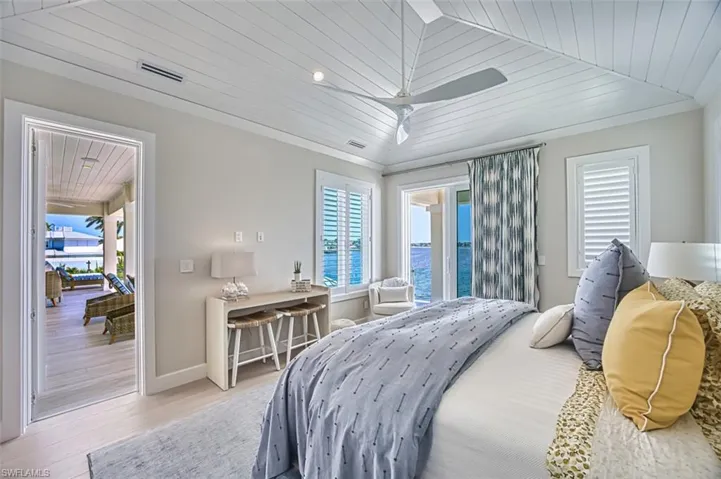 Bedroom featuring multiple windows, light wood-style flooring, wooden ceiling, and ceiling fan