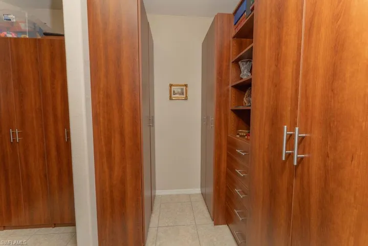 Walk in closet with light tile patterned floors