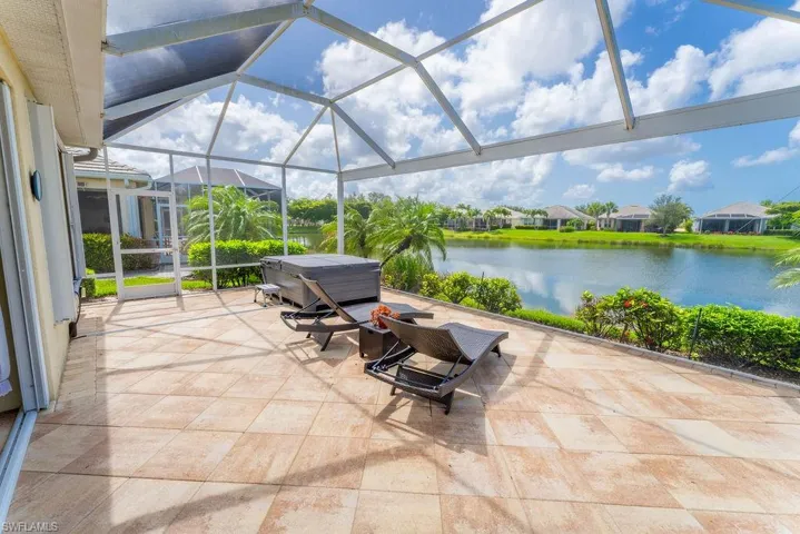 View of patio featuring a water view and glass enclosure