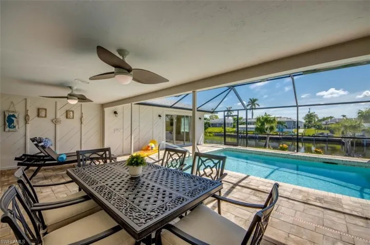 The property features a screened lanai with a swimming pool, offering views of the canal