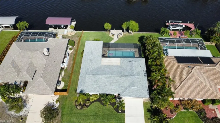 The property features a screened swimming pool and an expansive green lawn