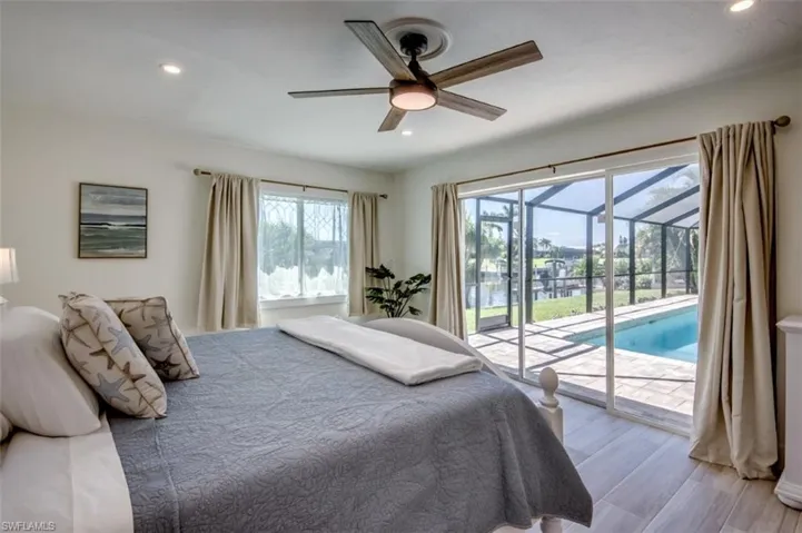 This room features a ceiling fan with integrated lighting, recessed lighting, and sliding glass doors that open to an outdoor living area