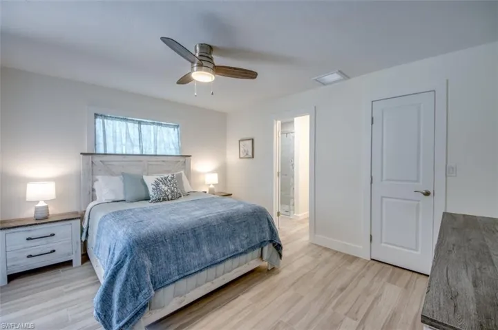 This bedroom features light wood-look flooring and a ceiling fan