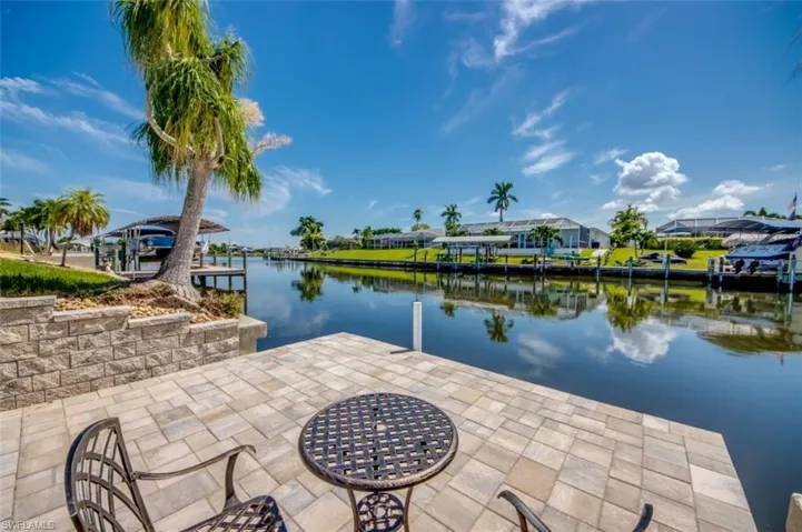 The property features a paved patio area with a canal view