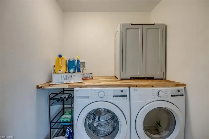 The property includes a dedicated laundry area with a light wood countertop and an overhead cabinet, providing practical storage solutions