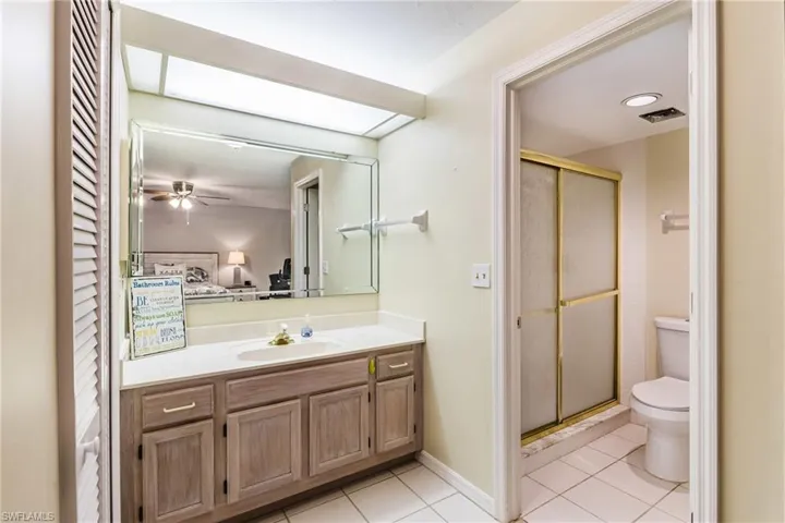 Bathroom featuring light tile patterned floors, vanity, a stall shower, and connected bathroom