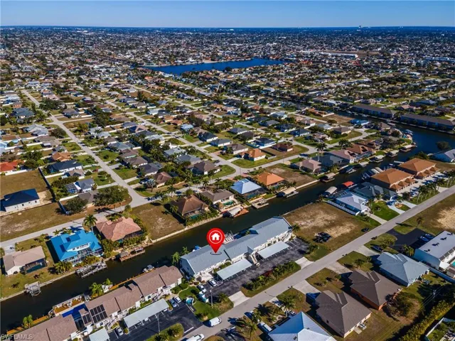 Aerial view of property's location featuring a nearby body of water and nearby suburban area