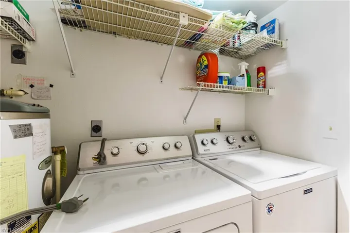 Laundry room featuring water heater and washing machine and clothes dryer
