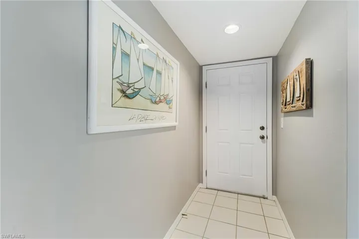 Doorway to outside with tile patterned flooring and recessed lighting