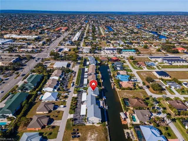Aerial view of property and surrounding area featuring nearby suburban area and a nearby body of water