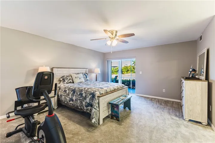 Bedroom featuring light carpet, access to exterior, and a ceiling fan