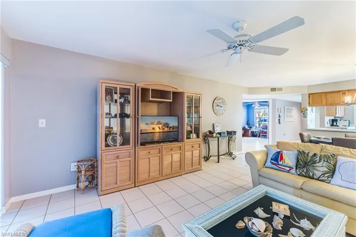 Living area featuring light tile patterned floors and a ceiling fan