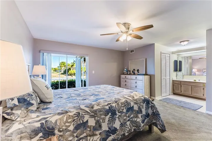 Bedroom featuring light carpet, access to outside, connected bathroom, and ceiling fan